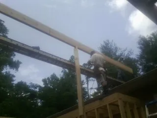 Carpenter setting a ridge beam over a new addition frame — Ice Dam Removal by Roofing Brothers in Kerman