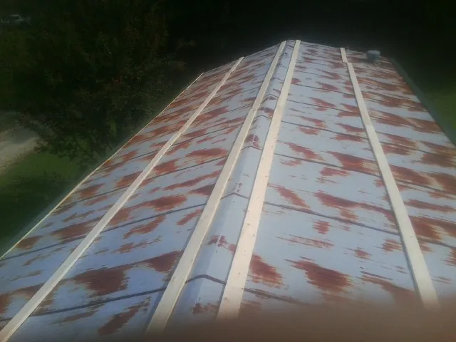Rusted metal roof panels with new wood purlins before replacement — Storm Damage Roof Repair in Kerman by Roofing Brothers