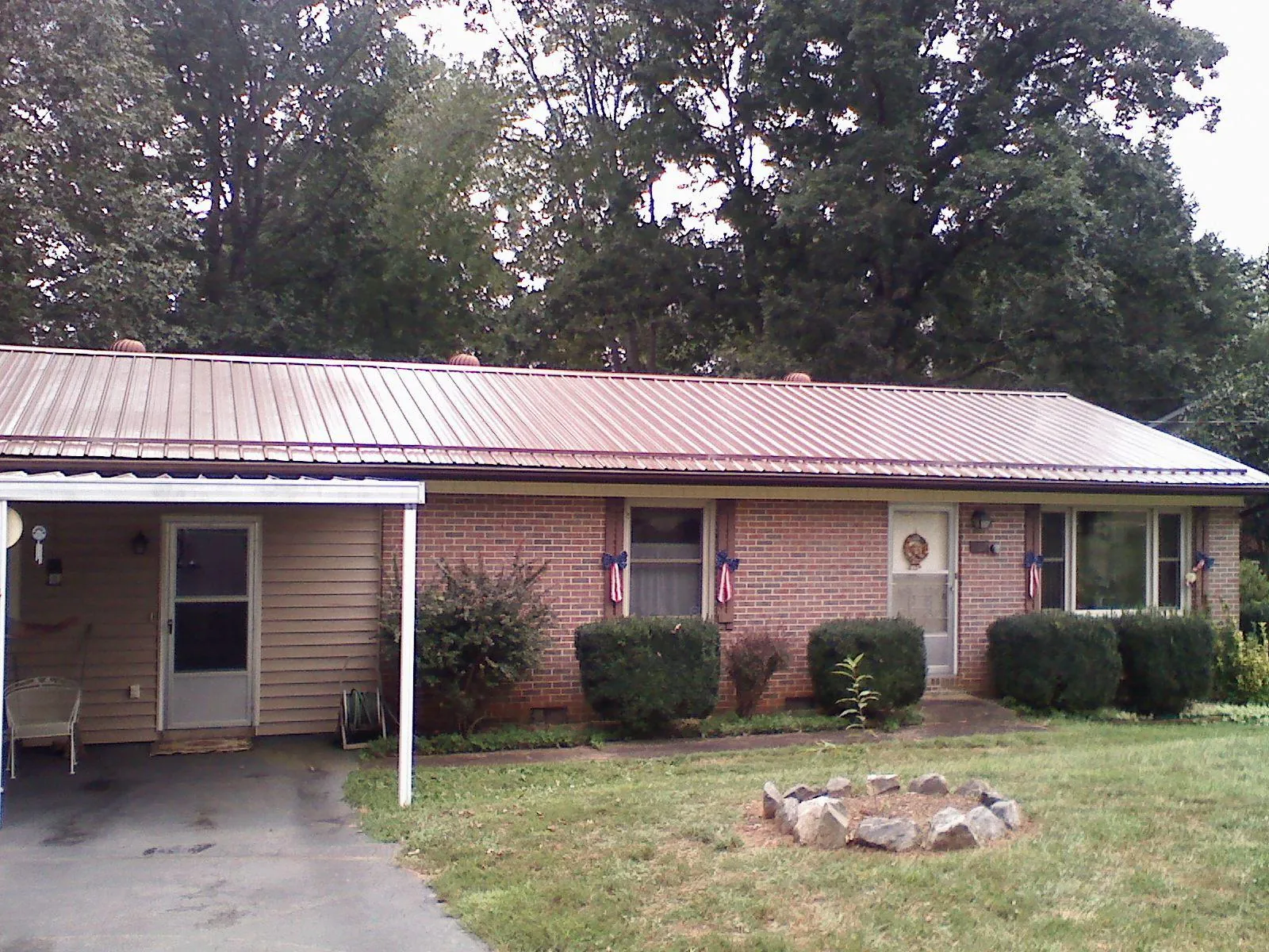 Bronze metal roof and carport on a brick ranch home — Roof Repair work by our crew in Kerman